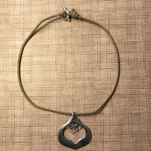 Beige suede cord with silver pendant.